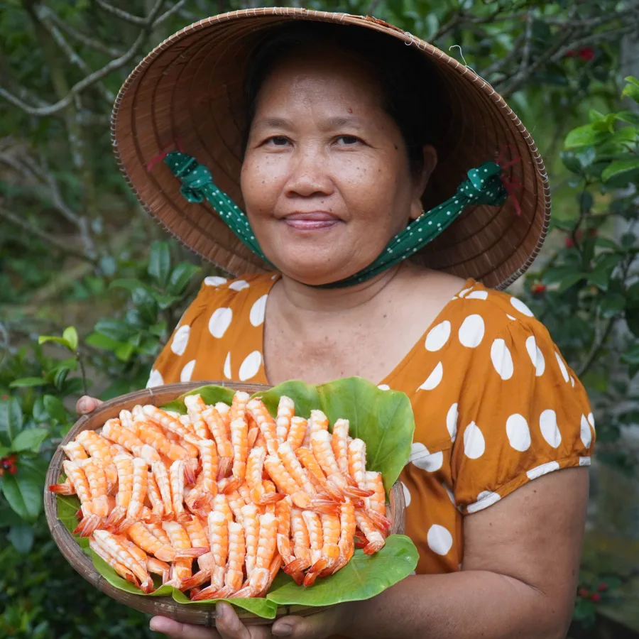 Cô Ba Miền Tây cầm mẹt tôm sấy dẻo thành phẩm tại vườn nhà