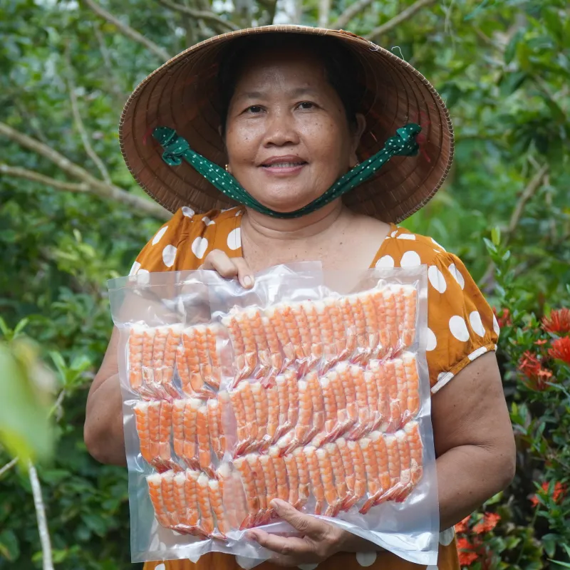 Cô Ba Miền Tây cầm bịch tôm sấy dẻo hút chân không
